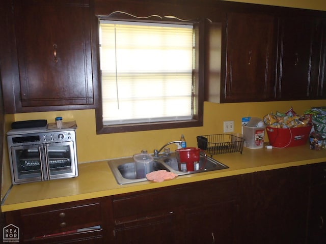 2009 Daugherty St, Newport, AR 72112 - kitchen featuring a toaster, reddish brown cabinets, light countertops, and a sink