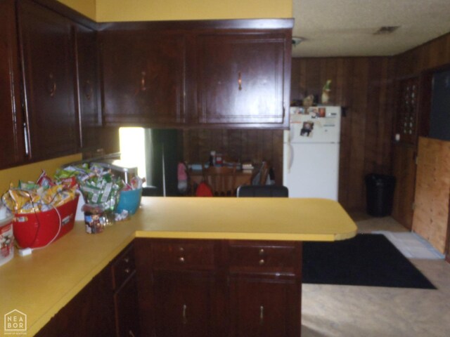 2009 Daugherty St, Newport, AR 72112 - kitchen featuring wooden walls, a peninsula, light countertops, and freestanding refrigerator