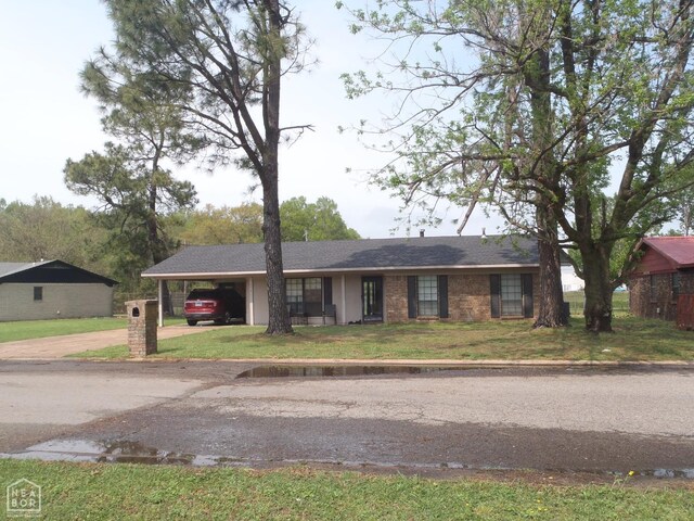 2009 Daugherty St, Newport, AR 72112 - ranch-style home with a front lawn, driveway, an attached carport, and brick siding