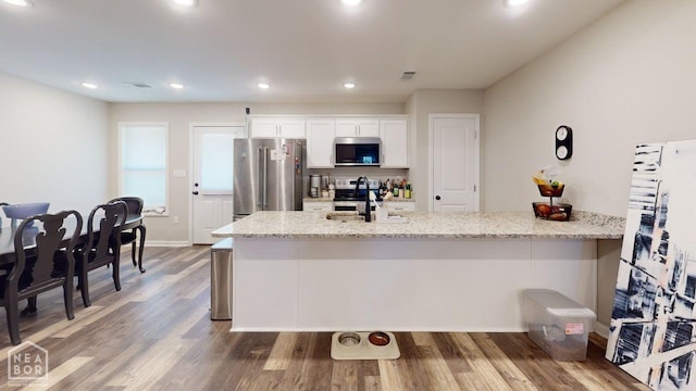 5632 Brookshire Dr, Jonesboro, AR 72405 - kitchen with wood finished floors, visible vents, a sink, appliances with stainless steel finishes, and white cabinetry