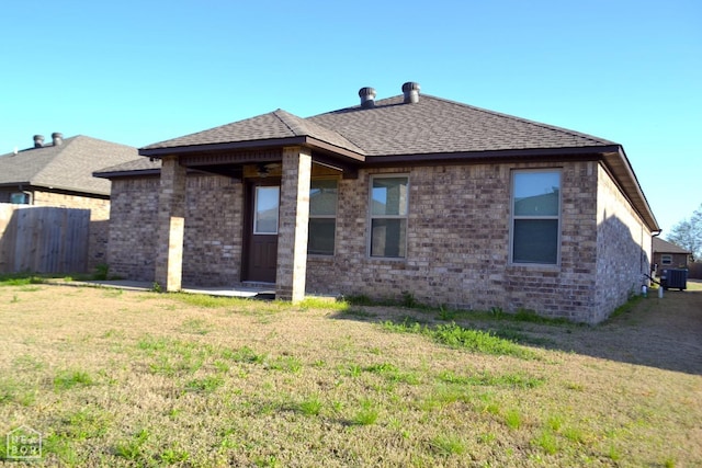 5632 Brookshire Dr, Jonesboro, AR 72405 - rear view of house featuring fence, roof with shingles, a yard, and central AC unit