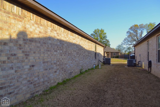 5632 Brookshire Dr, Jonesboro, AR 72405 - view of side of property with central air condition unit, brick siding, and a lawn