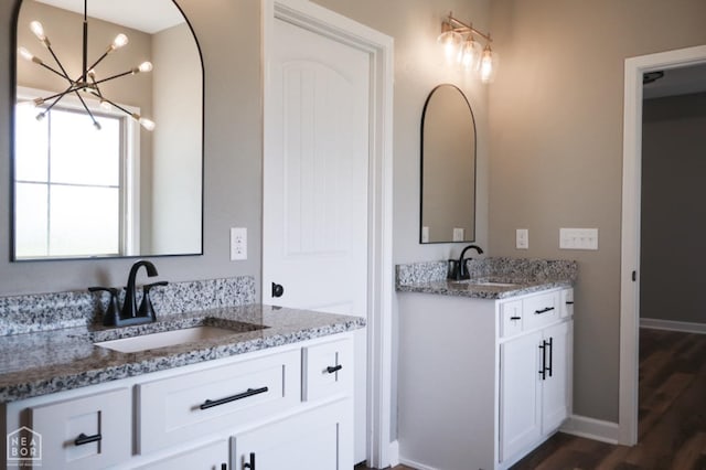 109 Old Eli Rd, Monette, AR 72447 - bathroom with two vanities, an inviting chandelier, wood finished floors, and a sink