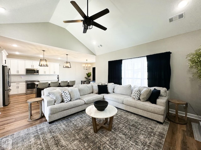 109 Old Eli Rd, Monette, AR 72447 - living area featuring ceiling fan with notable chandelier, visible vents, light wood finished floors, and high vaulted ceiling