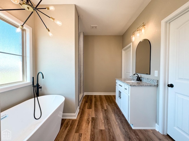 109 Old Eli Rd, Monette, AR 72447 - full bath with wood finished floors, vanity, a chandelier, a freestanding tub, and baseboards