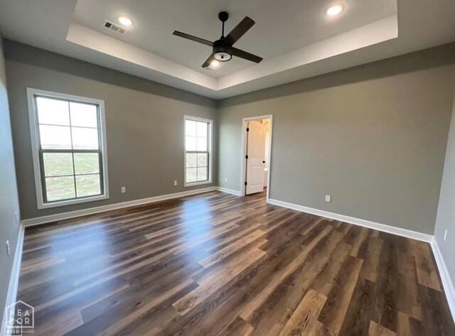 109 Old Eli Rd, Monette, AR 72447 - empty room with baseboards, visible vents, dark wood-style floors, and a raised ceiling