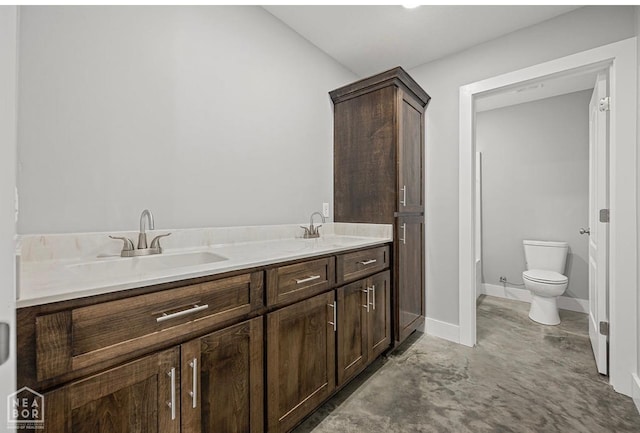 full bath featuring a sink, toilet, concrete floors, and baseboards