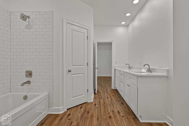 1816 N Oak, Brookland, AR 72417 - bathroom with wood finished floors, recessed lighting, washtub / shower combination, and double vanity