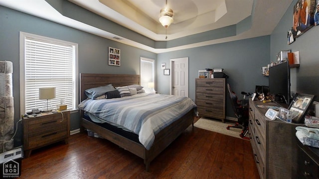403 Brookstone Dr, Jonesboro, AR 72404 - bedroom featuring a tray ceiling, dark wood-style flooring, and a ceiling fan