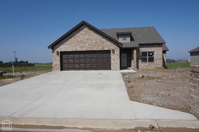 311 Hollis Cv, Bono, AR 72416 - view of front of home featuring a garage, brick siding, driveway, and roof with shingles