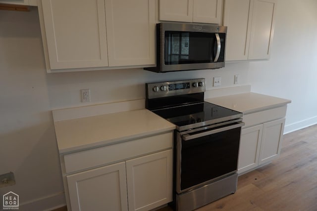 311 Hollis Cv, Bono, AR 72416 - kitchen featuring stainless steel appliances, light wood-style flooring, and light countertops