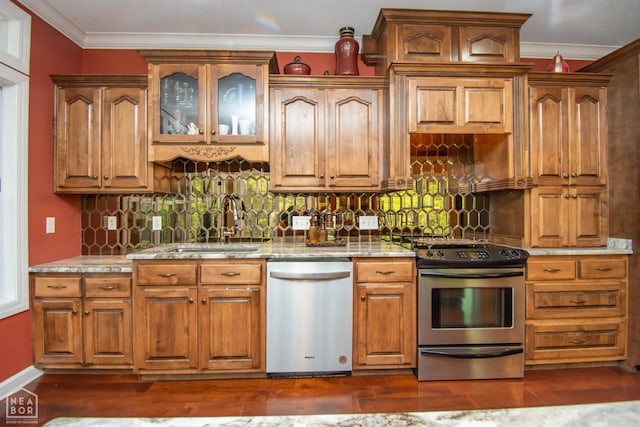 kitchen with a sink, backsplash, light stone counters, crown molding, and appliances with stainless steel finishes