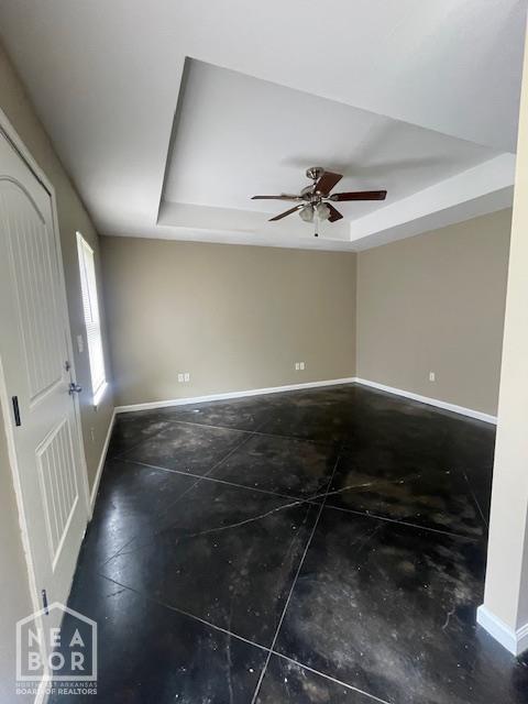 2206 Willow Rd, Jonesboro, AR 72401 - spare room with a raised ceiling, baseboards, and a ceiling fan