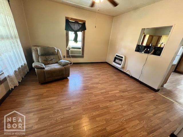 518 N 4th St, Paragould, AR 72450 - sitting room with heating unit, wood finished floors, ceiling fan, and cooling unit