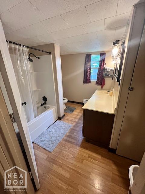 518 N 4th St, Paragould, AR 72450 - bathroom featuring wood finished floors, vanity, and shower / bath combo