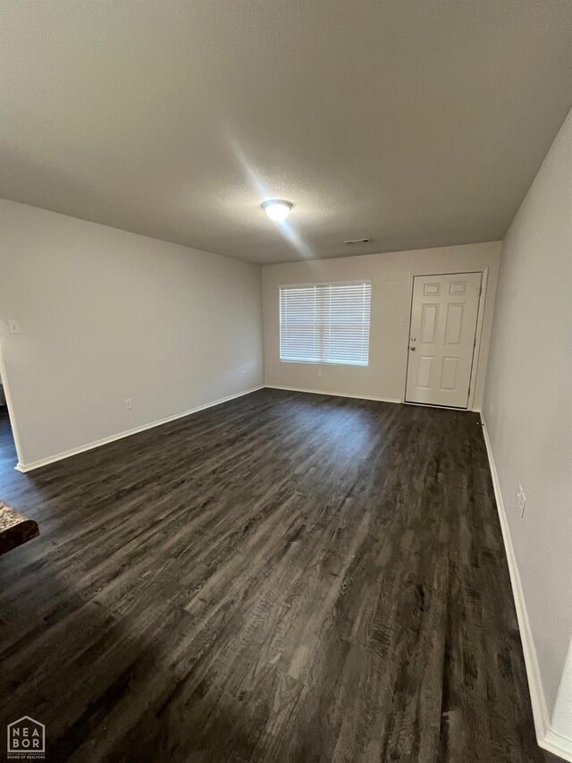 3721 Remington Dr, Jonesboro, AR 72404 - unfurnished living room with dark wood-style flooring and baseboards
