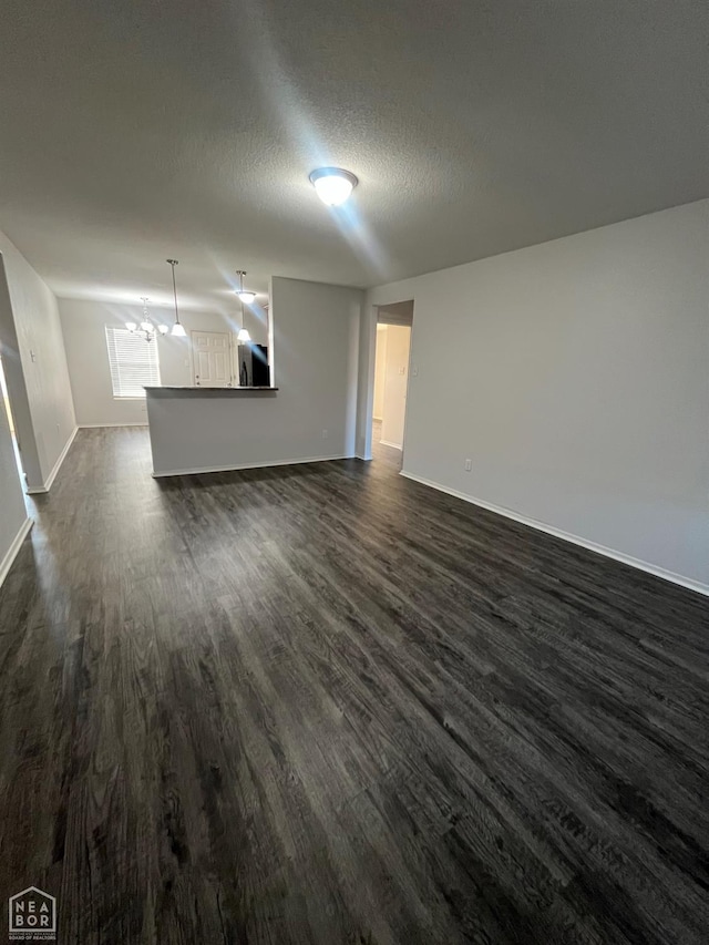 3721 Remington Dr, Jonesboro, AR 72404 - unfurnished living room featuring dark wood-style floors, baseboards, and a textured ceiling