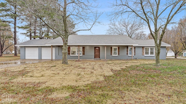 ranch-style home featuring brick siding, an attached garage, a front lawn, and concrete driveway