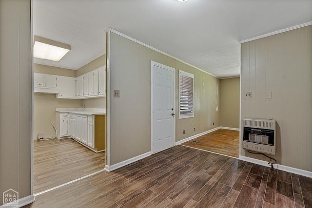 34 Adams St, Wilson, AR 72395 - unfurnished living room featuring heating unit, wood finished floors, crown molding, and baseboards