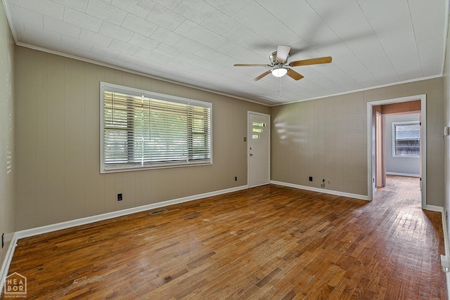 34 Adams St, Wilson, AR 72395 - empty room with ornamental molding, a ceiling fan, hardwood / wood-style floors, baseboards, and wood walls