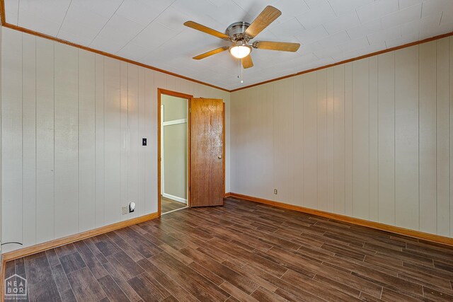 34 Adams St, Wilson, AR 72395 - spare room featuring crown molding, dark wood-style flooring, a ceiling fan, baseboards, and wood walls