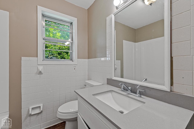 34 Adams St, Wilson, AR 72395 - full bath featuring tile walls, toilet, vanity, a wainscoted wall, and a shower