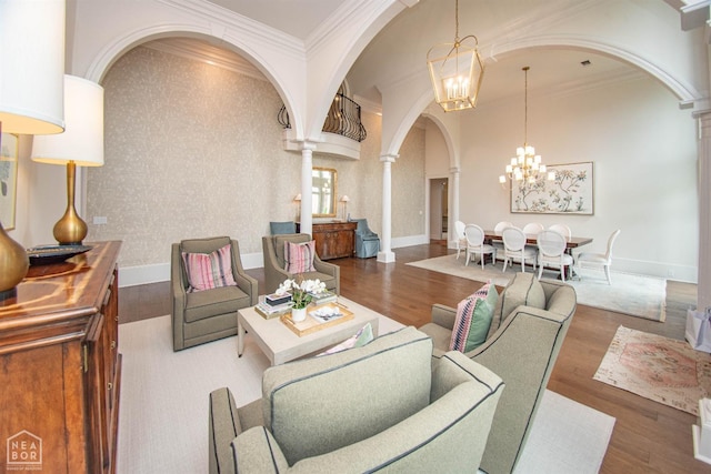 1203 Dove Rd, Jonesboro, AR 72401 - living area with arched walkways, ornamental molding, decorative columns, wood finished floors, and a notable chandelier