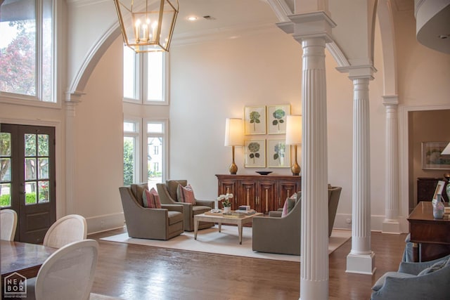 1203 Dove Rd, Jonesboro, AR 72401 - living room featuring arched walkways, ornamental molding, decorative columns, wood finished floors, and a high ceiling