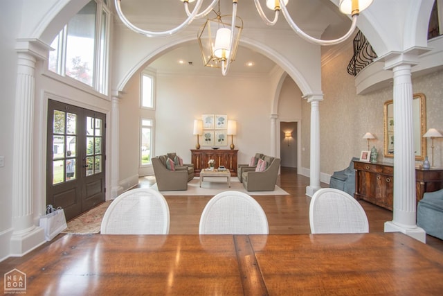 1203 Dove Rd, Jonesboro, AR 72401 - dining space with arched walkways, wood finished floors, decorative columns, a notable chandelier, and french doors