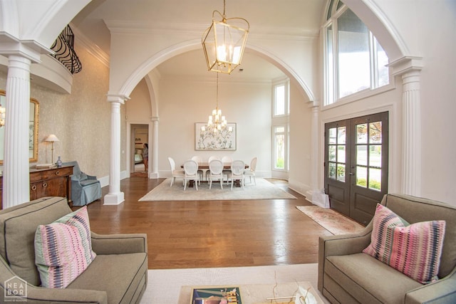 1203 Dove Rd, Jonesboro, AR 72401 - living room featuring a high ceiling, a notable chandelier, crown molding, and decorative columns