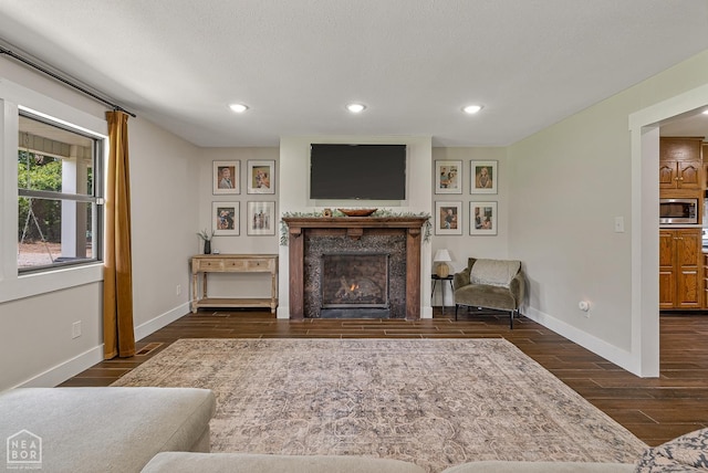 1766 Greene Road 326, Bono, AR 72416 - living room featuring baseboards, dark wood-style flooring, a premium fireplace, and recessed lighting