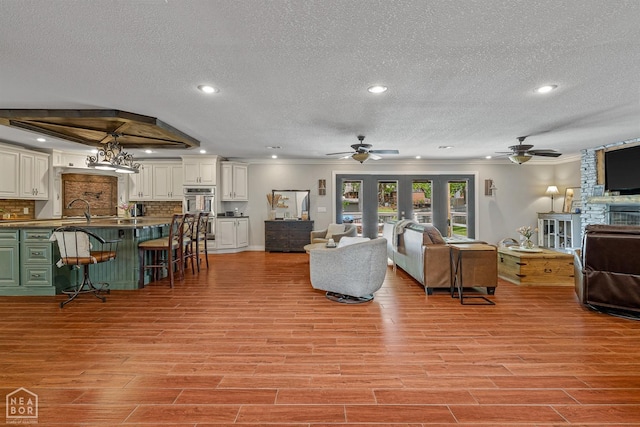 1616 Neely Rd, Jonesboro, AR 72404 - living room with ornamental molding, a ceiling fan, a textured ceiling, and light wood-type flooring