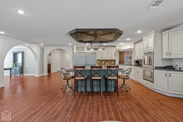 1616 Neely Rd, Jonesboro, AR 72404 - dining room with arched walkways, wood finished floors, visible vents, and recessed lighting