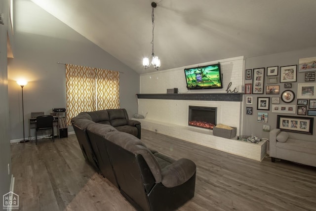 1705 Loberg Ln, Jonesboro, AR 72401 - living area featuring wood finished floors, a fireplace, a chandelier, and lofted ceiling