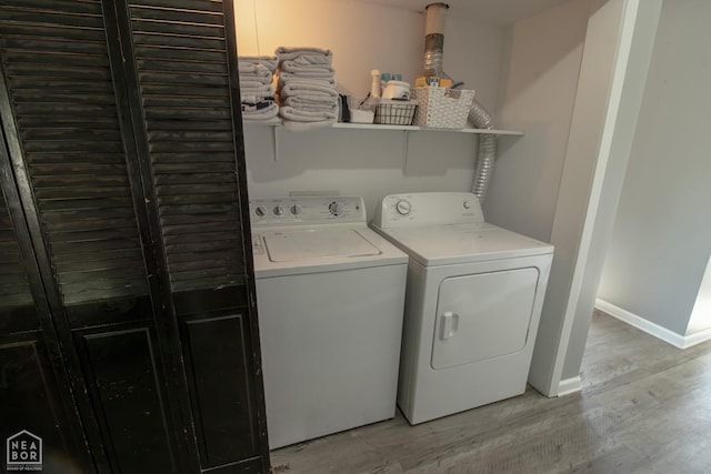 1705 Loberg Ln, Jonesboro, AR 72401 - laundry area with washing machine and dryer, light wood-style floors, and baseboards