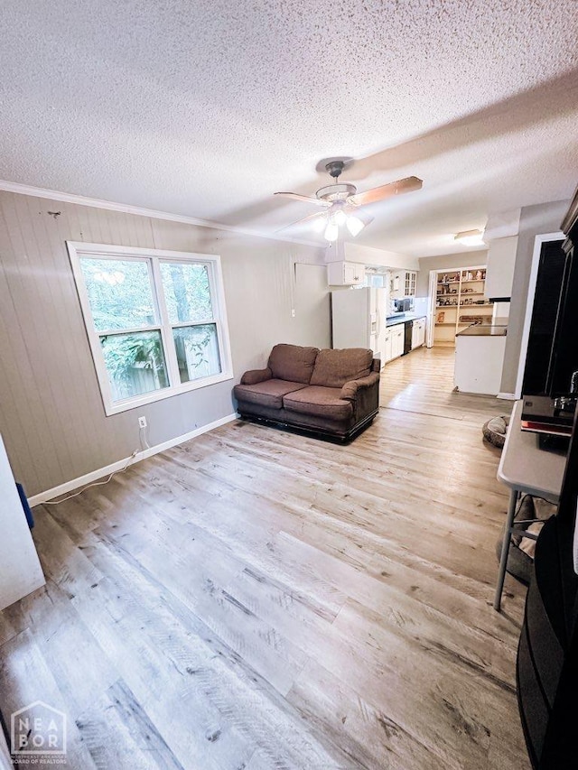 1705 Loberg Ln, Jonesboro, AR 72401 - living area with a textured ceiling, a ceiling fan, light wood finished floors, baseboards, and ornamental molding