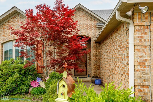 103 Hollis Cv, Bono, AR 72416 - entrance to property featuring brick siding and roof with shingles
