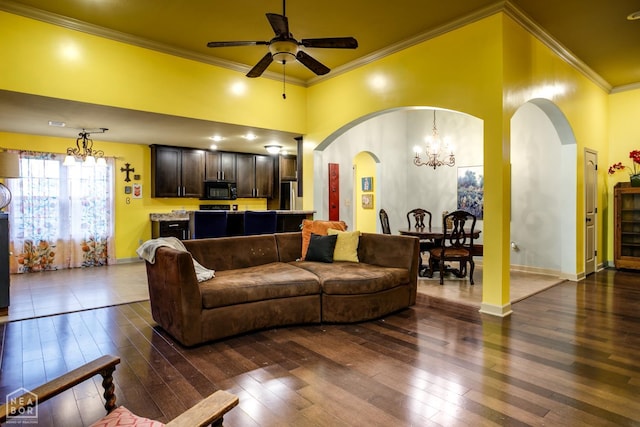 103 Hollis Cv, Bono, AR 72416 - living room featuring crown molding, dark wood-type flooring, a chandelier, a ceiling fan, and arched walkways