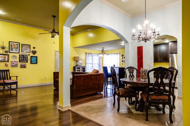 103 Hollis Cv, Bono, AR 72416 - dining space featuring a chandelier, crown molding, ceiling fan, arched walkways, and dark wood-style floors