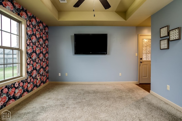 103 Hollis Cv, Bono, AR 72416 - unfurnished living room featuring a tray ceiling, ceiling fan, carpet floors, baseboards, and wallpapered walls