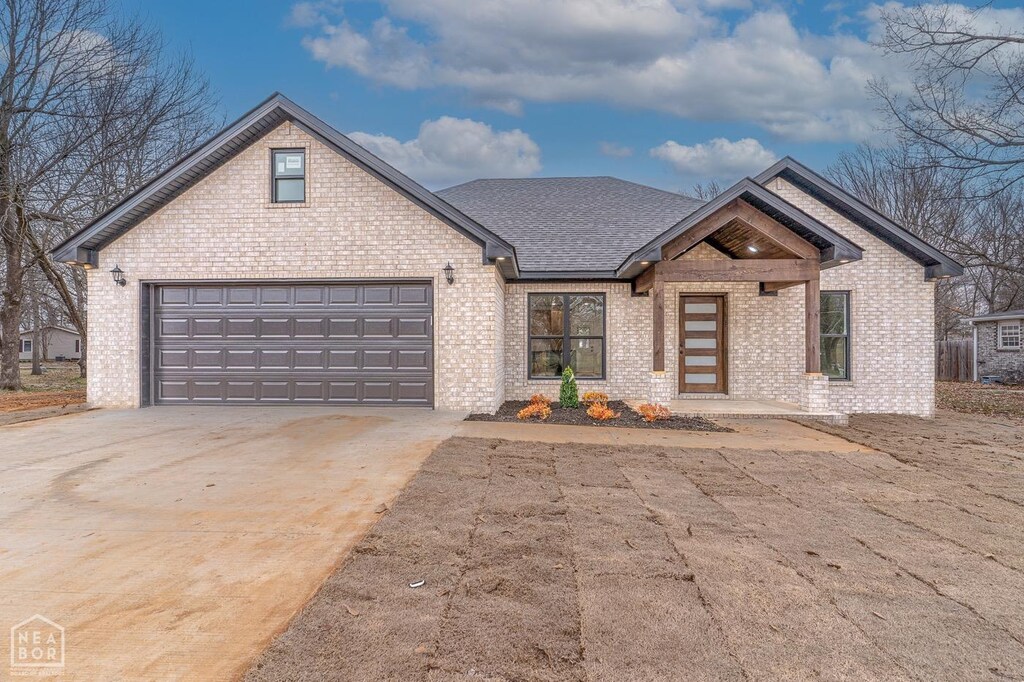 view of front of house with brick siding, driveway, and an attached garage