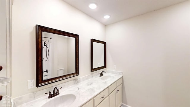 bathroom featuring a sink, baseboards, and double vanity