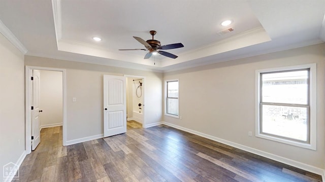 spare room featuring dark wood-style flooring, visible vents, a tray ceiling, and crown molding
