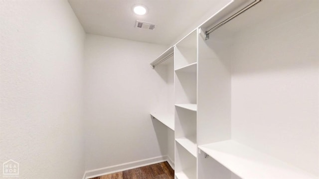 spacious closet with dark wood-type flooring and visible vents