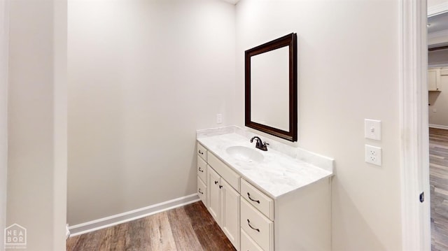 bathroom featuring vanity, baseboards, and wood finished floors