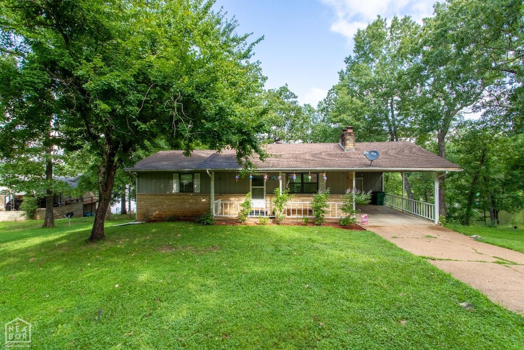 1322 Hummingbird Ln, Horseshoe Bend, AR 72512 - view of front facade with a porch, a chimney, a front yard, an attached carport, and concrete driveway