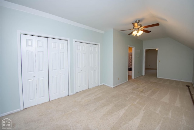 2205 Oak Hollow Ln, Jonesboro, AR 72401 - unfurnished bedroom featuring two closets, light colored carpet, lofted ceiling, and a ceiling fan