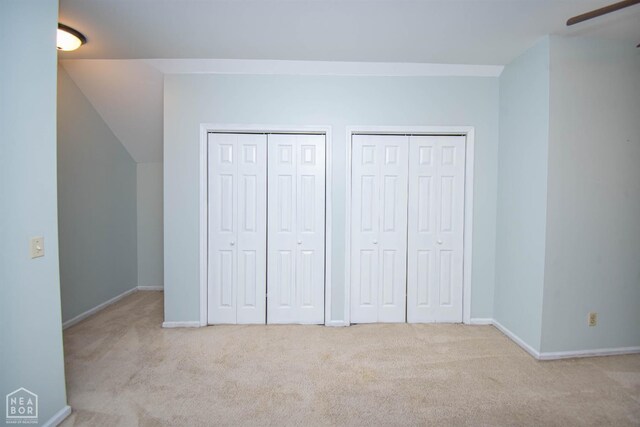 2205 Oak Hollow Ln, Jonesboro, AR 72401 - unfurnished bedroom featuring multiple closets, carpet, and lofted ceiling