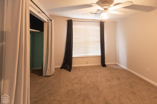 unfurnished bedroom with baseboards, a ceiling fan, light colored carpet, and a textured ceiling