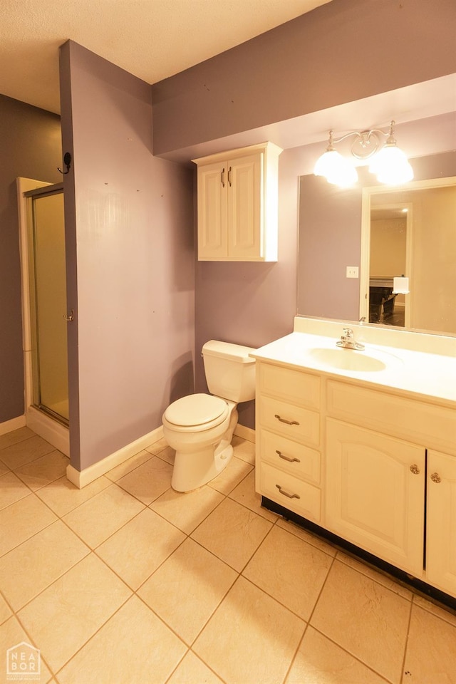 bathroom featuring baseboards, a shower stall, tile patterned flooring, and vanity